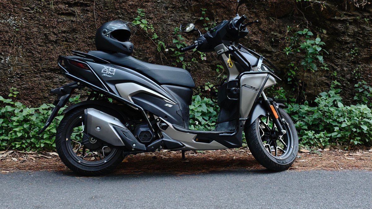 Scooter 125 gris stationné devant un mur végétalisé pour illustrer les critères à comparer avant un devis d'assurance